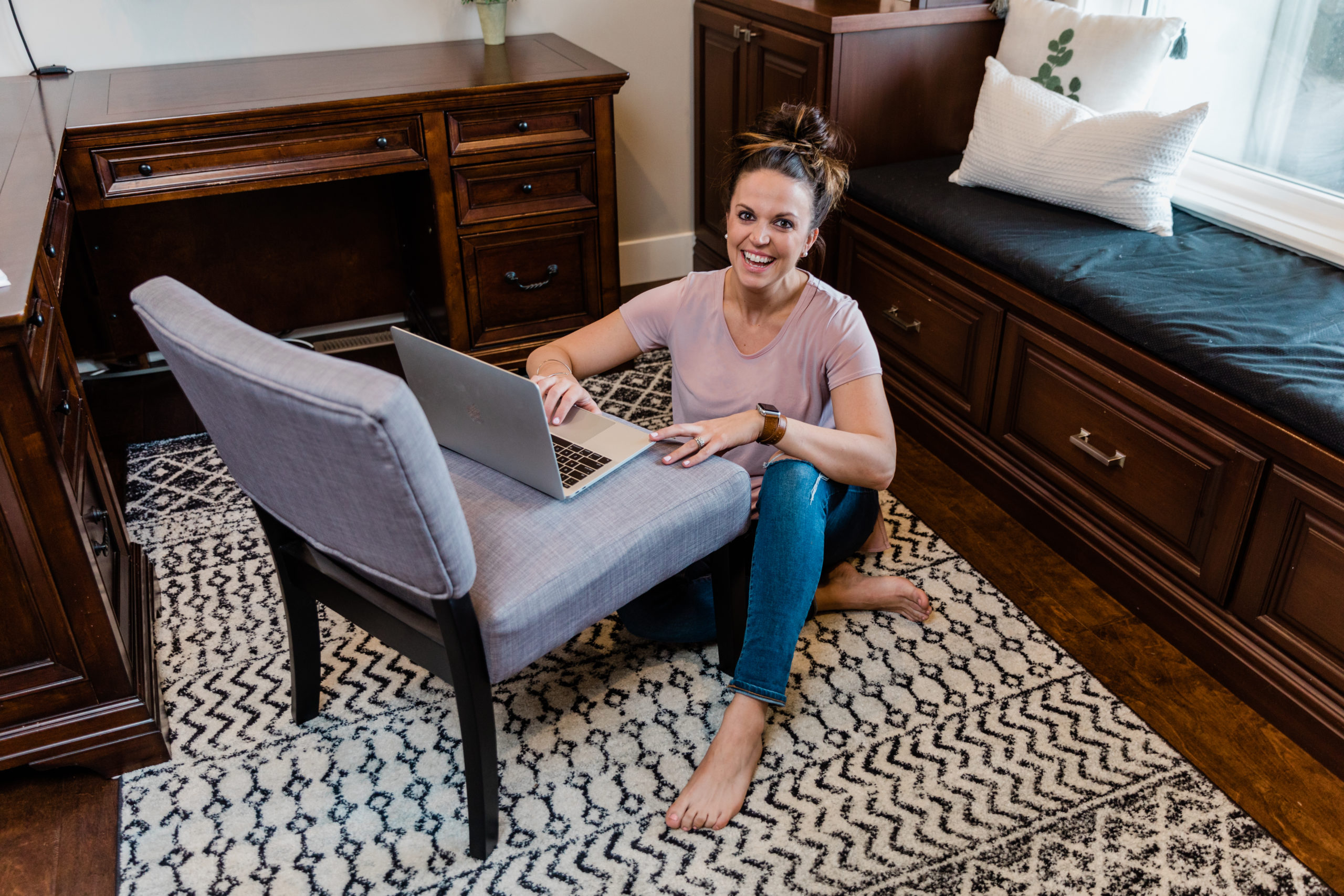 Woman on Laptop Laughing at Camera